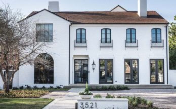 White brick house facade and old roof style with black framed windows